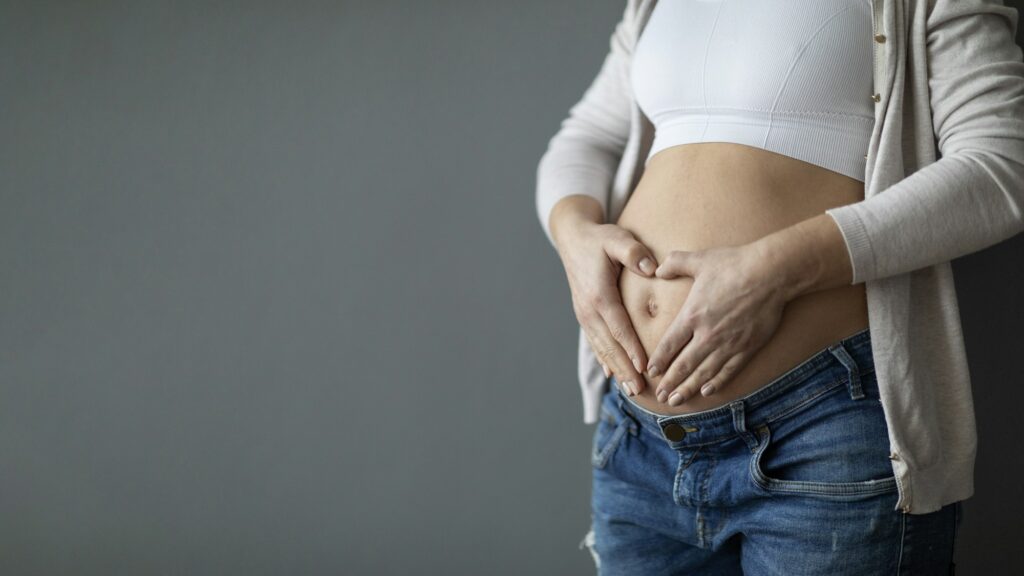 Pregnanct Woman Holding Hands In Heart Shape On Her Big Belly